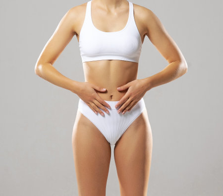 Young, fit and beautiful woman in white swimsuit over white background. The concept of healthcare, diet, sport and fitness.の写真素材
