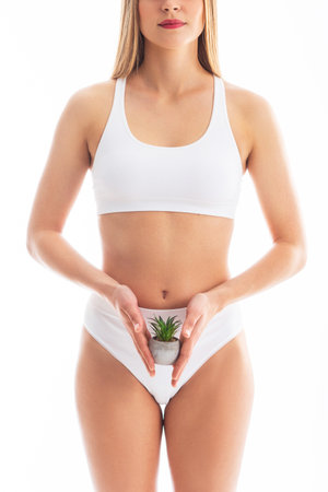 Young, fit and beautiful blond woman in white swimsuit isolated on grey background. Healthcare, diet, sport and fitness concept.の写真素材