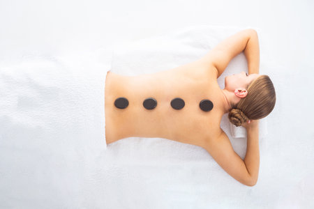 Young woman getting massaging treatment over white. Spa, healthcare and recreation concept.の写真素材