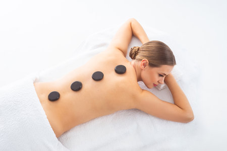 Young woman getting massaging treatment over white. Spa, healthcare and recreation concept.の写真素材