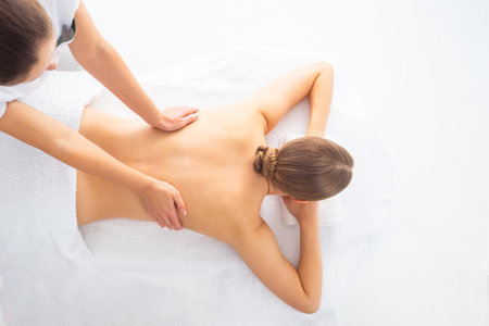 Young woman getting massaging treatment over white. Spa, healthcare and recreation concept.の写真素材