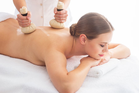 Young woman getting massaging treatment over white. Spa, healthcare and recreation concept.の写真素材