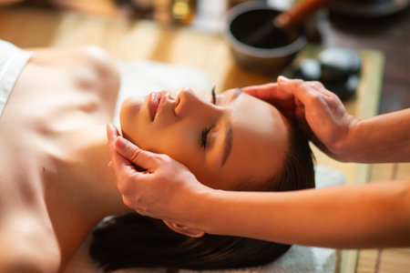 Young woman getting massaging treatment over exotic background. Spa, healthcare and recreation concept.の写真素材