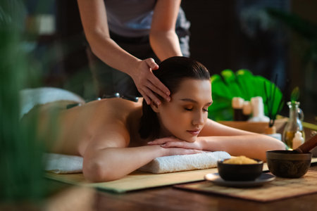Young woman getting massaging treatment over exotic background. Spa, healthcare and recreation concept.の写真素材