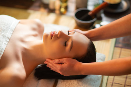 Young woman getting massaging treatment over exotic background. Spa, healthcare and recreation concept.の写真素材