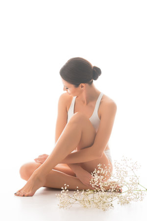 Young, fit and beautiful brunette woman in white swimsuit isolated on white background. Healthcare, diet, sport and fitness concept.の写真素材