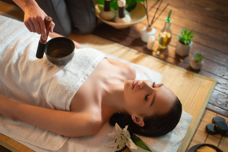 Young woman getting massaging treatment over exotic background. Spa, healthcare and recreation concept.の写真素材