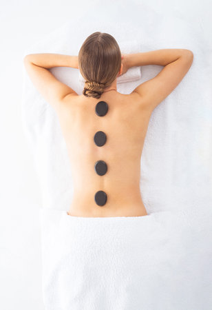 Young woman getting massaging treatment over white. Spa, healthcare and recreation concept.の写真素材