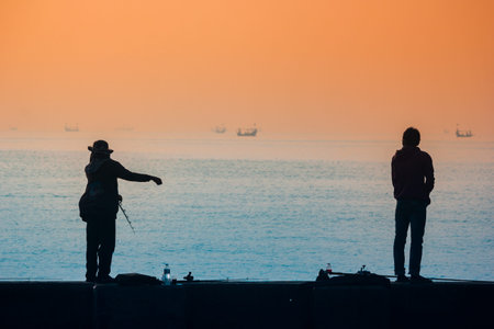Silhouette of a man and a woman on the pier watching the sunset