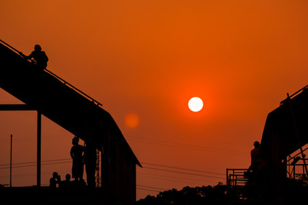 Silhouette of construction workers on the construction site at sunset.の写真素材