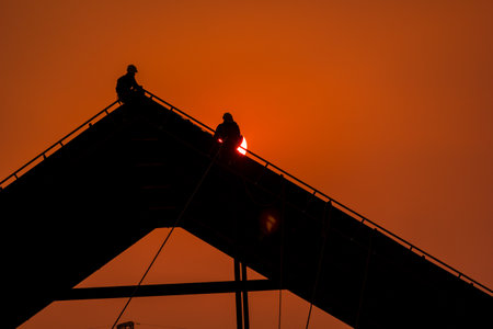 Silhouette of workers on construction site at sunset, Thailand.の写真素材