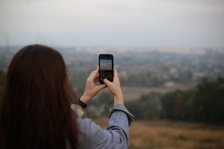 woman taking a photo of the landscape using phone