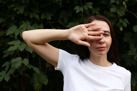 portrait of a woman covering her eyes with her handの写真素材