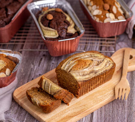 Homemade banana bread sliced on a wooden board close-up.の写真素材