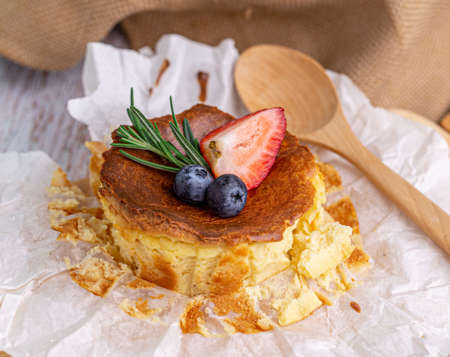 Burnt Cheese Cake, Basque Cheesecake with strawberry and blueberry toppings on Parchment Paper, close-upの写真素材