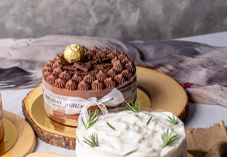 Chocolate cake decorated with chocolate and white ribbon for birthday cake on wooden board.