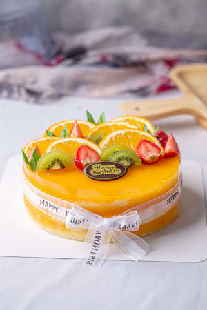 Fresh orange cake soft fudge decorated with orange kiwi fruit and strawberry for birthday cake.の写真素材