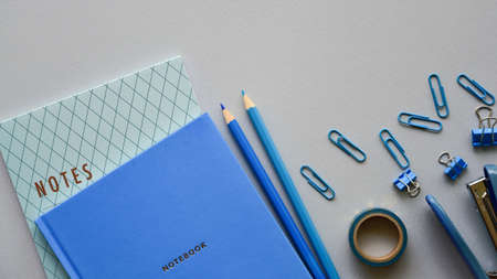 Stationery in blue and its shades on a paper background. Top view. Copy space.の写真素材