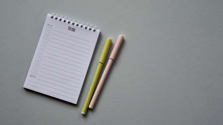 Notepad with two pens on a blue paper background. Top view. Close-up. Flat lay.の写真素材