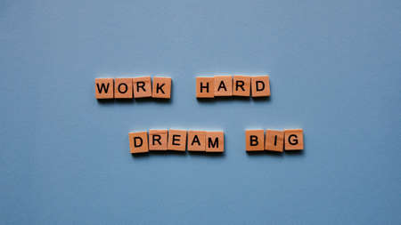 Words "Work hard. Dream big" on a blue paper background. Motivating web banner.の写真素材
