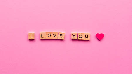 Words "I love you" on a pink paper background. Can be used as greeting card for wedding, anniversary, Women's Day or Valentine's Day.の写真素材