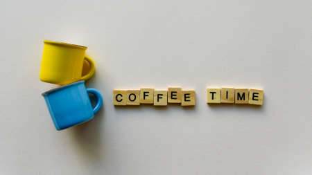 Two empty coffee cups and wooden words "Coffee time" on a beige paper background. Top view. Close-up. Flat lay.の写真素材