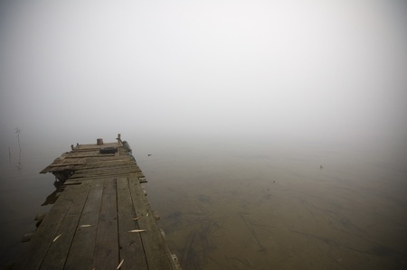 Wooden jetty on a fog covered lakeの写真素材