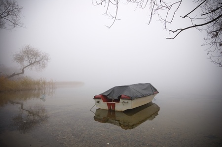 Boat on a fog covered lakeの写真素材