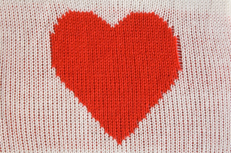 Knitted red heart shape on white 