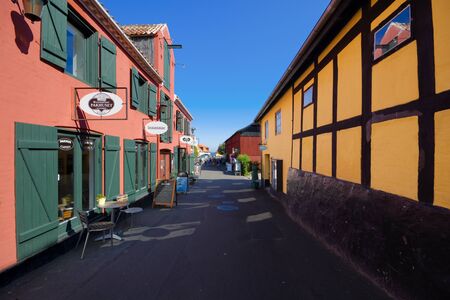 SVANEKE, DENMARK - AUGUST 23, 2018: Traditional colorful half-timbered houses in Svaneke. Pakhuset Restaurant on the left - one of the biggest summer restaurants on Bornholm island.のeditorial素材