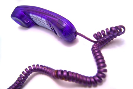 Purple handset with a wire on whiteの写真素材