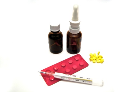 Pills, bottles, and thermometer on white backgroundの写真素材