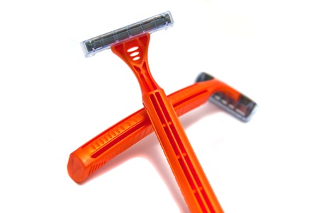 two orange razor blades close-up on white backgroundの写真素材
