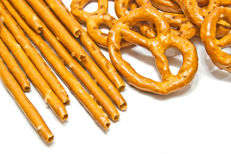 breadsticks and salted pretzels on white background