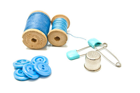 thread, buttons and thimble on white background