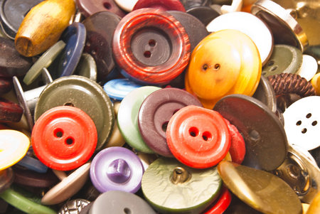 heap of various colorful clothing buttons closeup