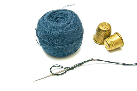 ball of yarn and two thimble on white