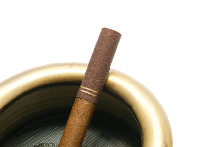 cigarette with filter in metal ashtray on white closeupの写真素材