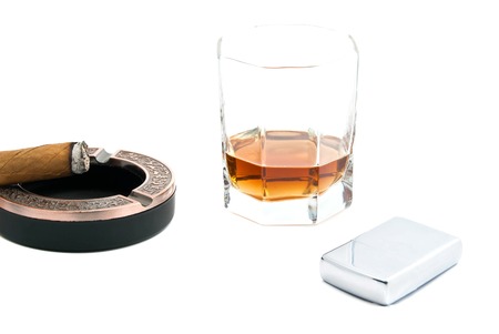 cigar in ashtray, lighter and cognac on white closeupの写真素材