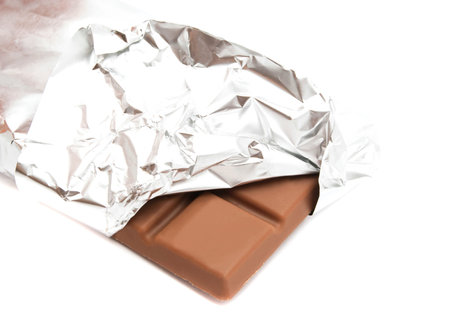 bar of chocolate in a foil closeup on white
