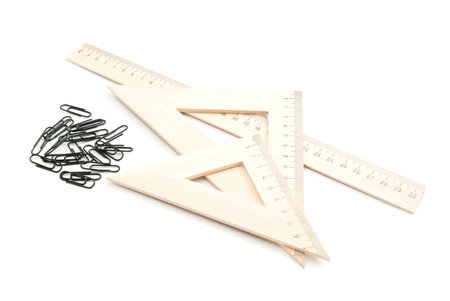 wooden ruler and black clips on white background