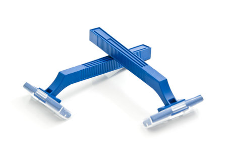 pair of blue plastic razors closeup on white background