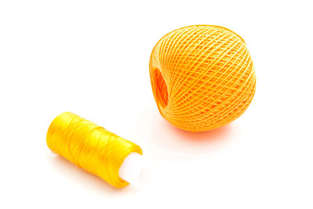 pair of yellow spools of thread on white