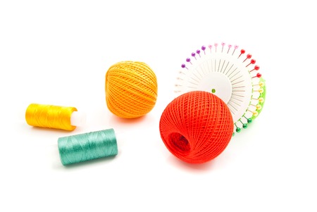 colored pins and tangles of thread closeup on whiteの写真素材