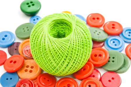 green ball of thread and buttons on white backgroundの写真素材