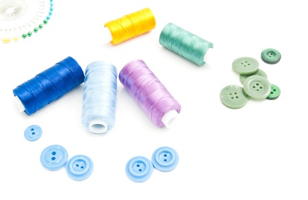 colored pins, spools of thread and buttons on white backgroundの写真素材