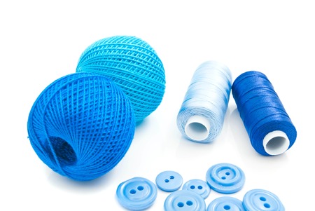 blue spools of thread and buttons on white backgroundの写真素材