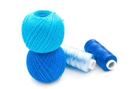 blue spools of thread closeup on white background