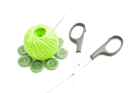 needle, green buttons, scissors and thread on whiteの写真素材