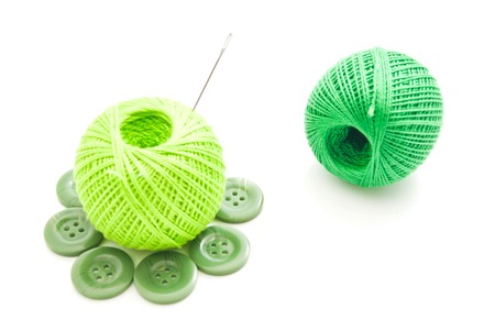 needle, green buttons and thread on whiteの写真素材